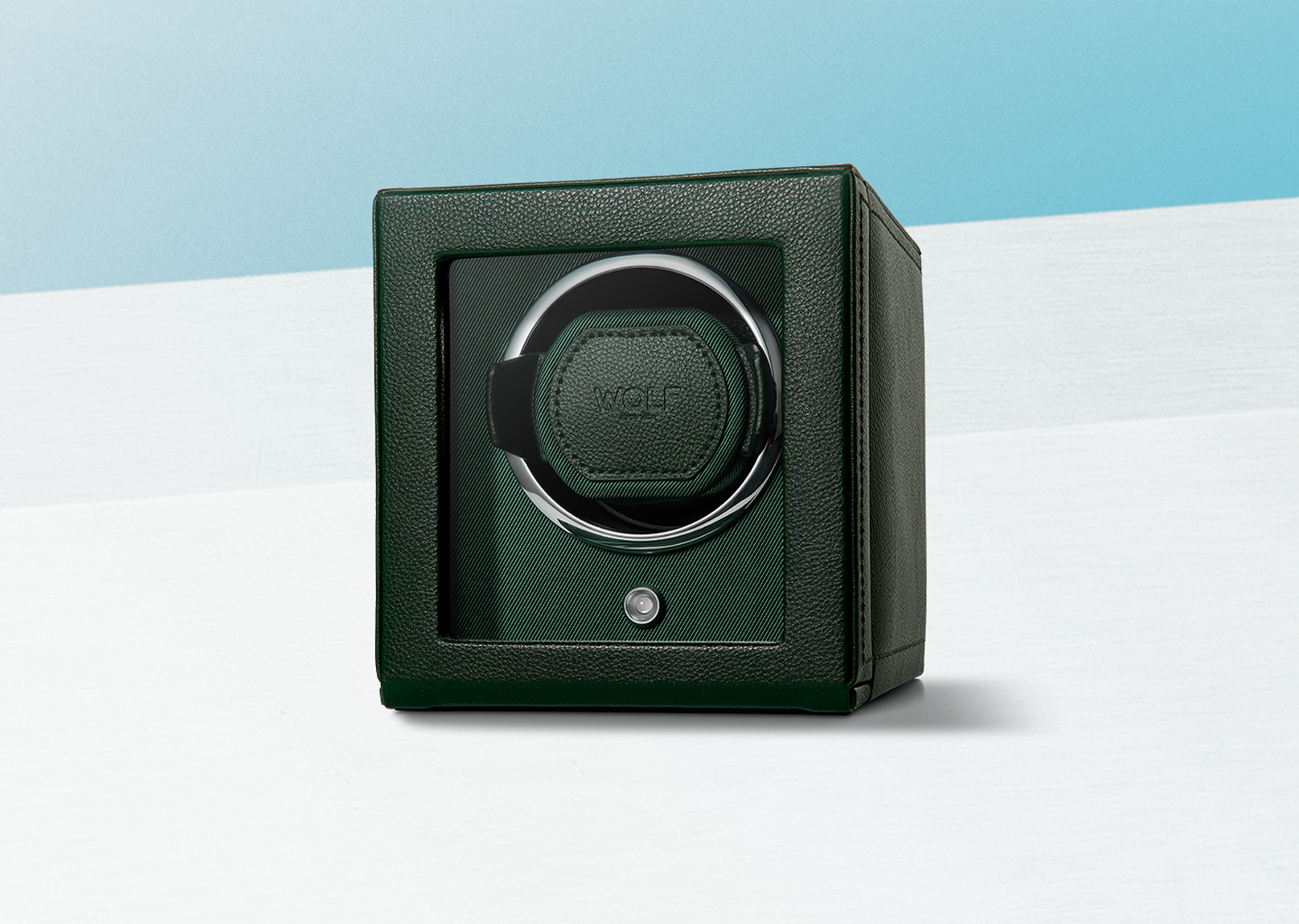 Un remontoir de montre en cuir WOLF sur un fond bleu.